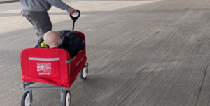 Child being pulled in red Warrior Wagon