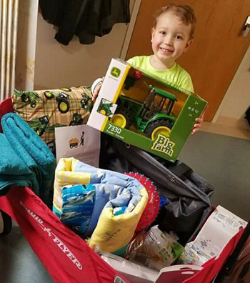 Little boy with his wagon holding a John Deere toy